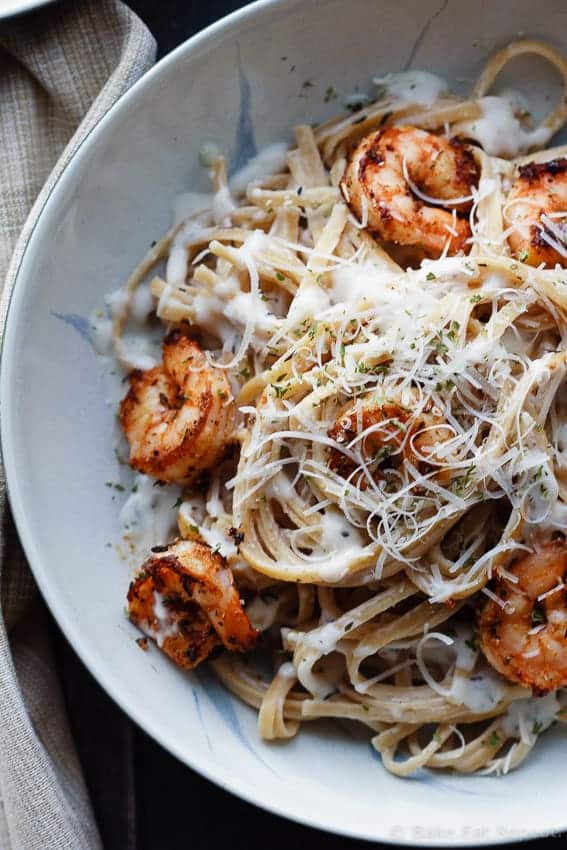 cajun shrimp alfredo close up in grey bowl with shredded parmesan cheese