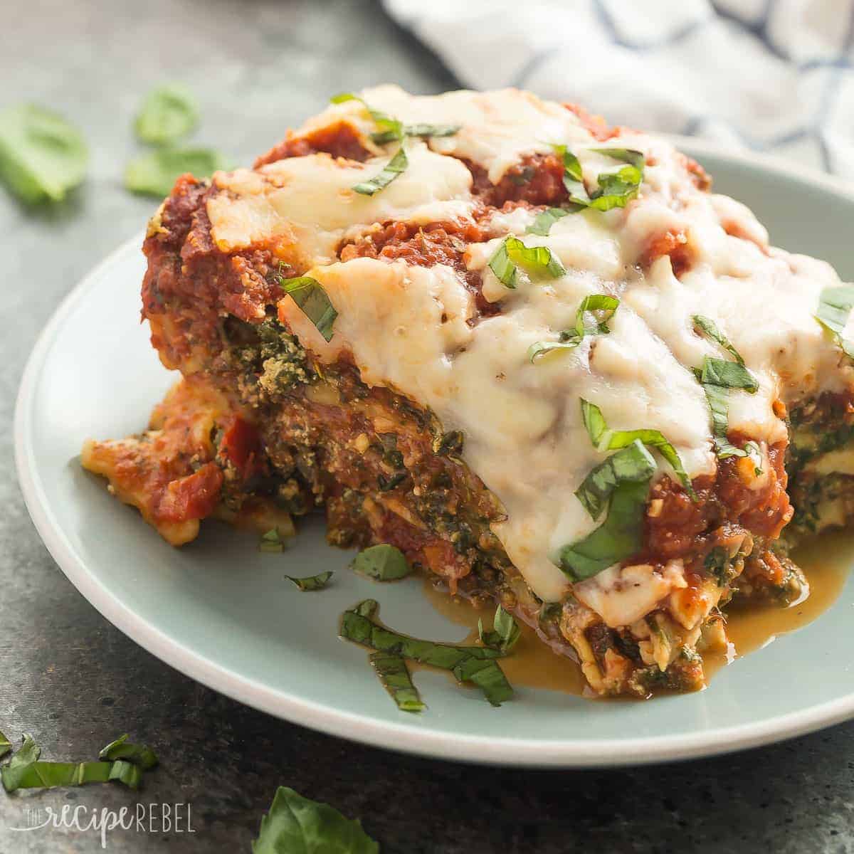 square image of piece of slow cooker lasagna on blue plate on grey background