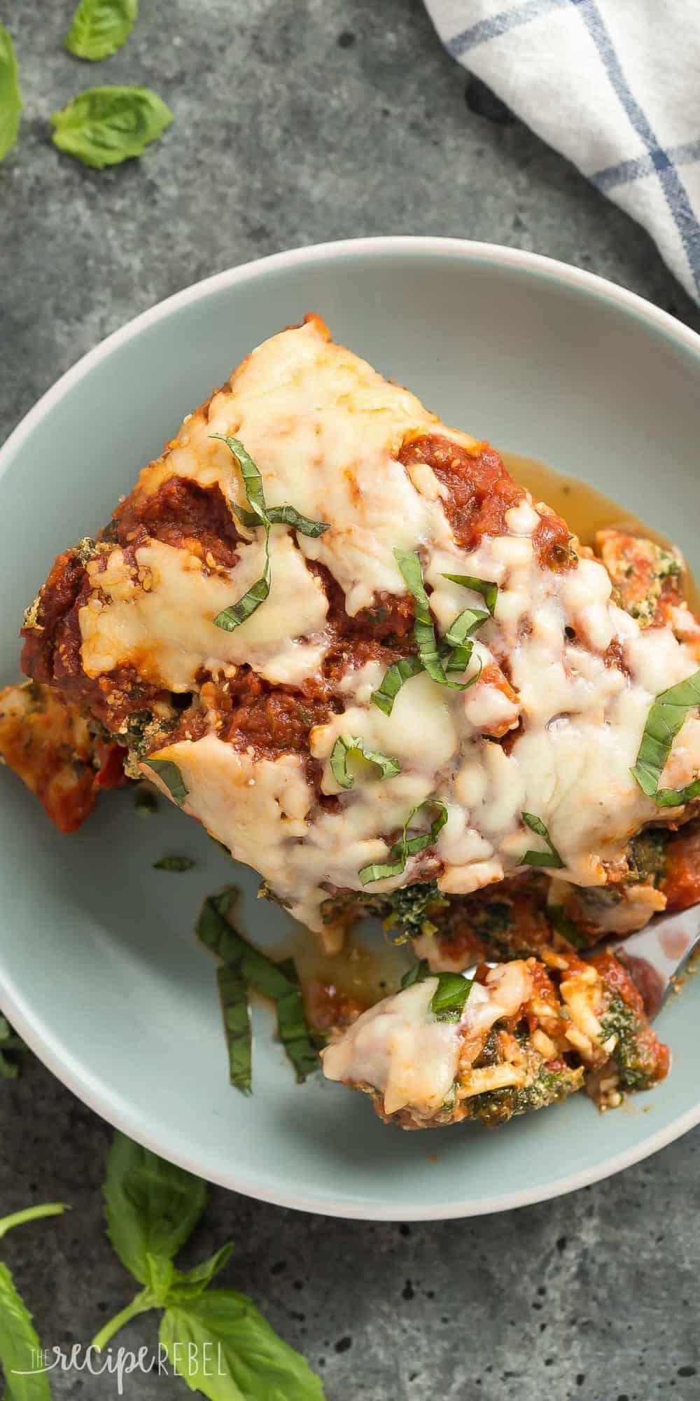 tall overhead image of piece of slow cooker lasagna on blue plate with fresh basil sprinkled on top