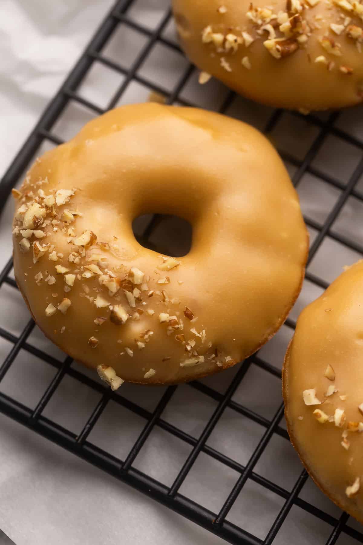 close up image of a single baked apple donuts with brown sugar glaze.