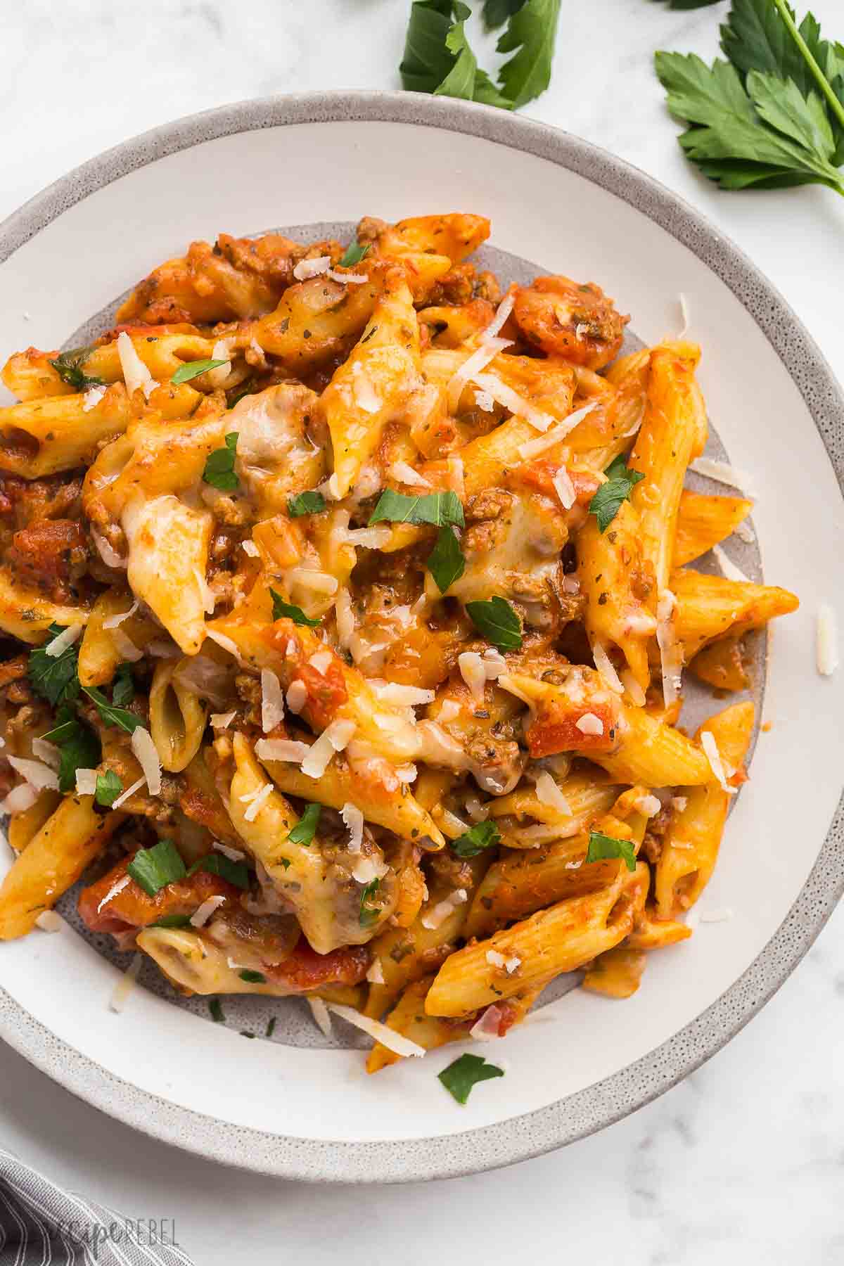 plate of slow cooker baked ziti with parmesan and parsley on top.