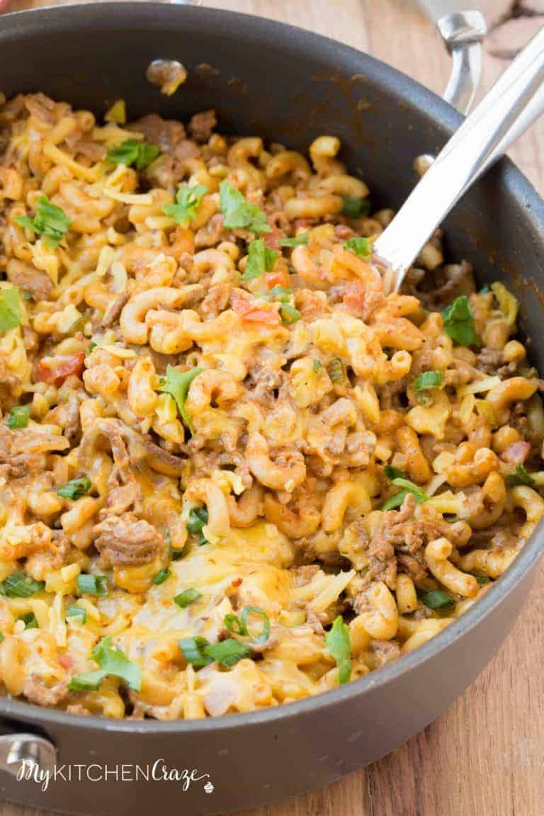 one pot cheeseburger macaroni in black skillet with spoon stuck in