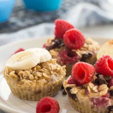These easy baked oatmeal cups use only FOUR basic ingredients and they're perfect for breakfast, school lunches or snacks! Naturally sweetened, packed with protein, make ahead and freezer friendly with 3 different variations: raspberry chocolate chip, peanut butter banana and apple cinnamon.