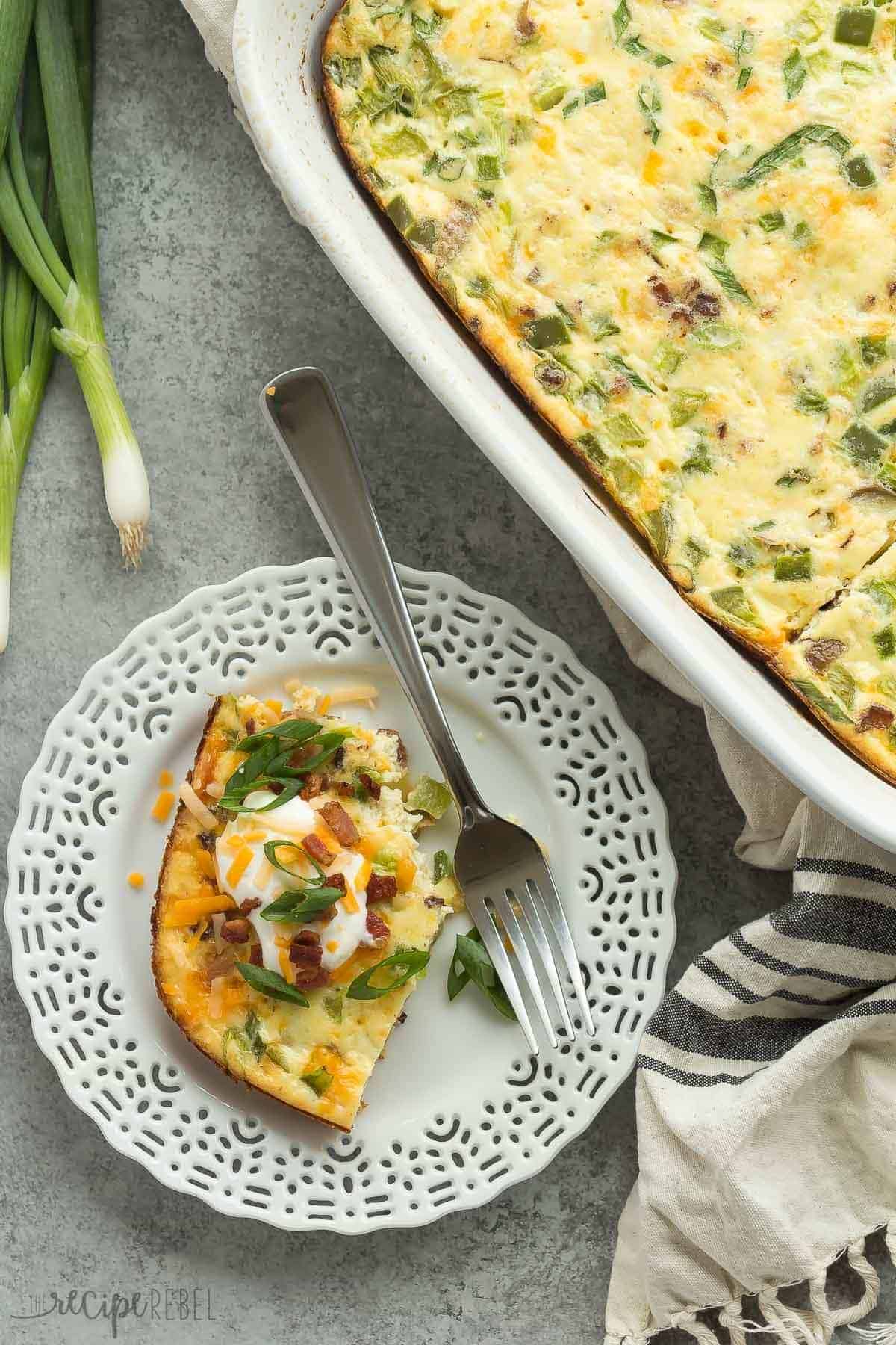 loaded baked potato breakfast casserole on white plate with casserole dish on the side