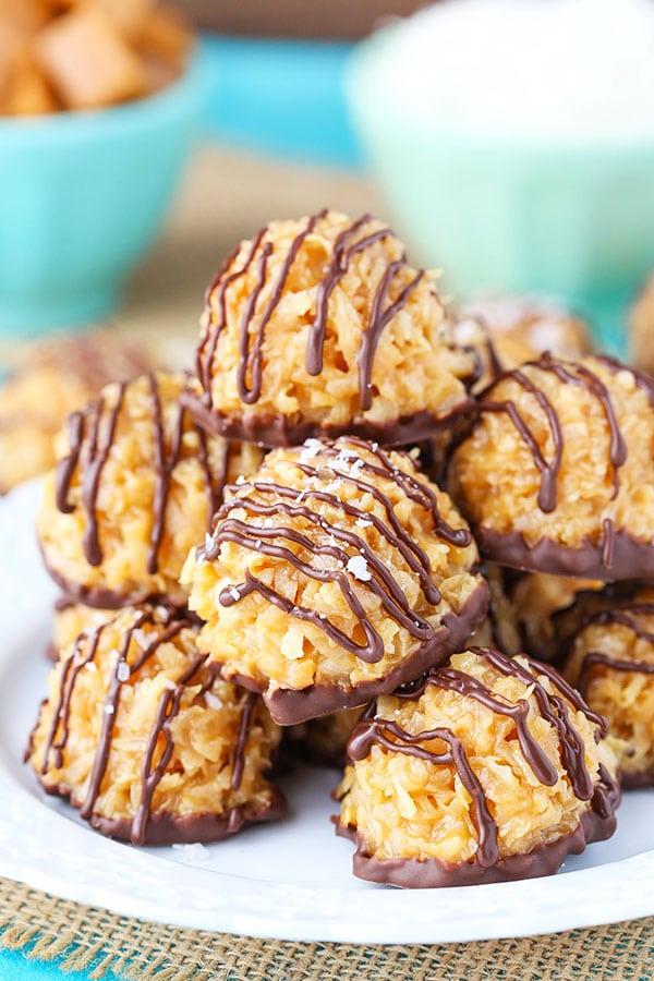 no bake salted caramel coconut macaroons sacked on a white plate with bright blue bowls in the background