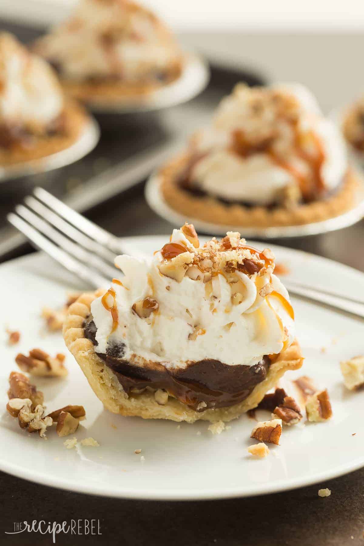 one mini turtle pudding pie on white plate with bite taken to reveal chocolate filling