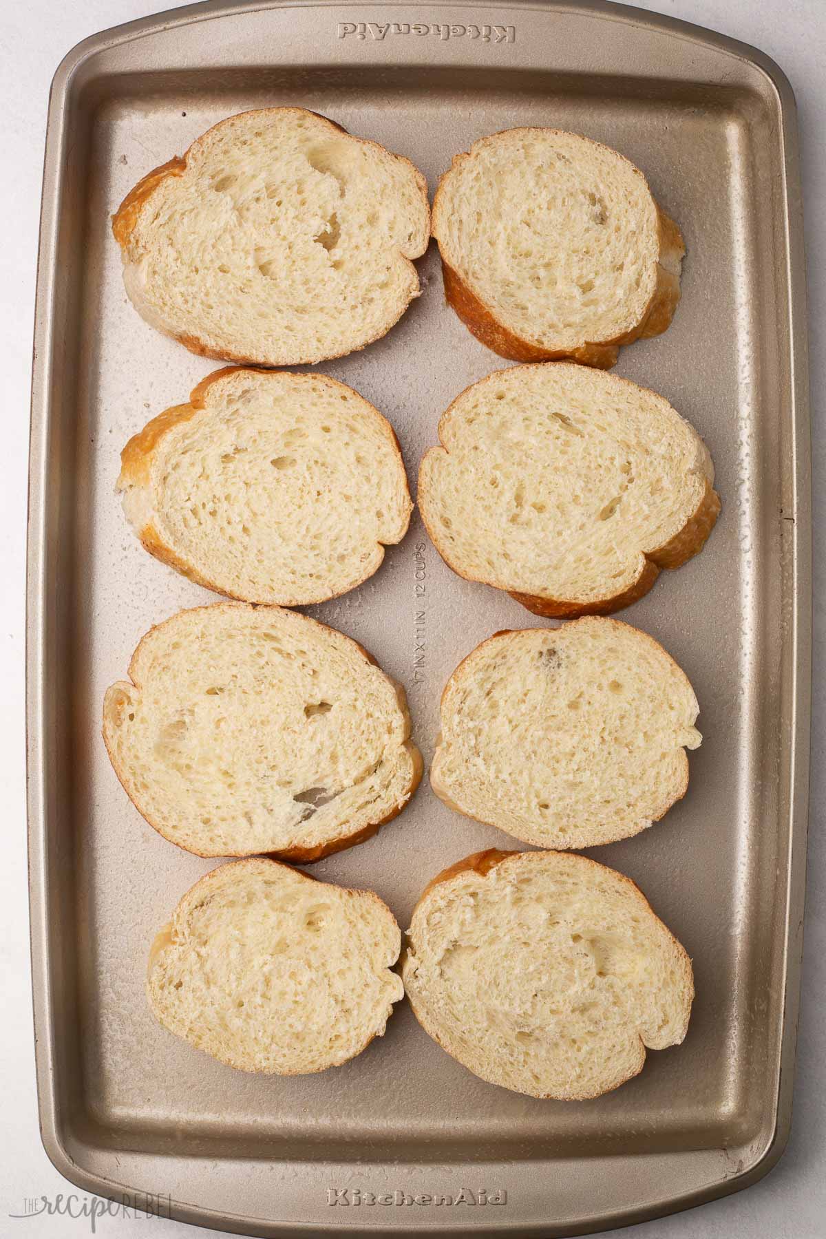 overhead image of french bread slices on a sheet pan.