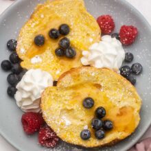 overhead image of baked lemon french toast with blueberries and raspberries.