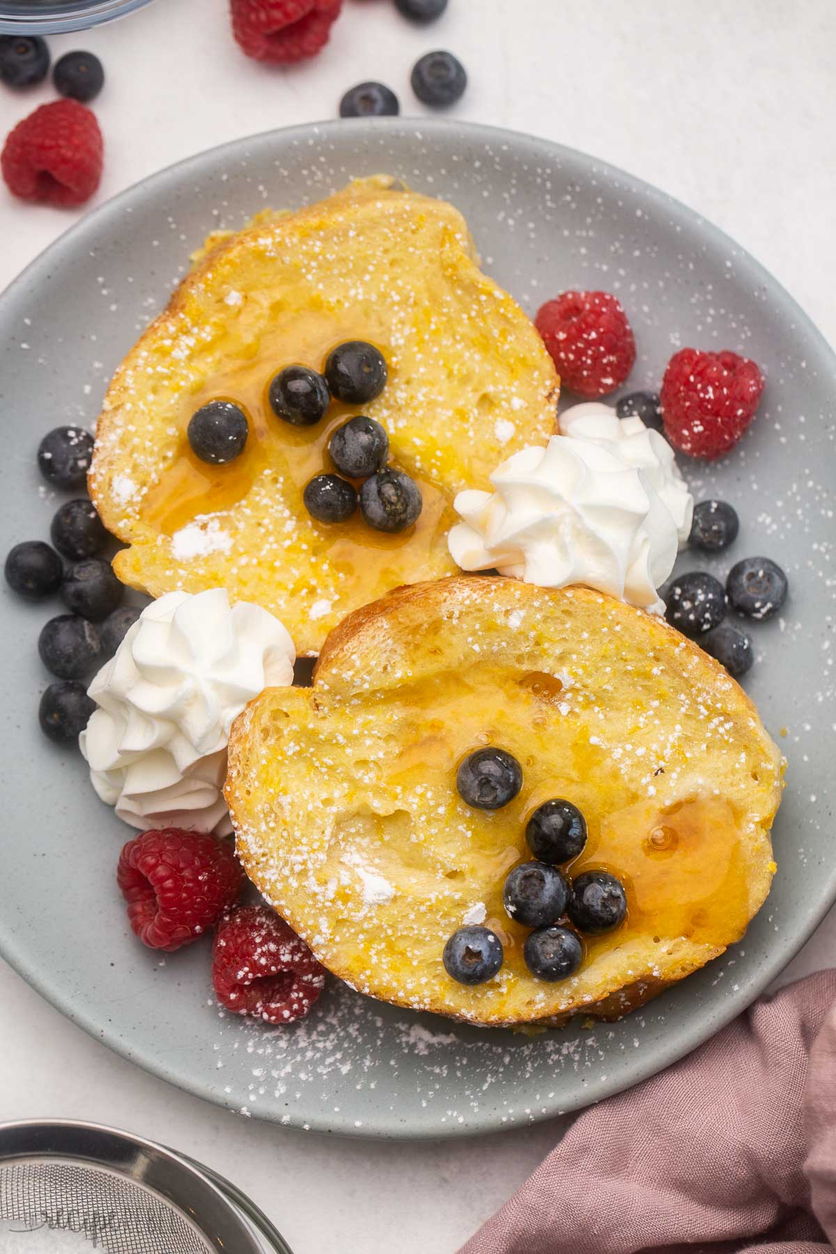 overhead image of baked lemon french toast with blueberries and raspberries.