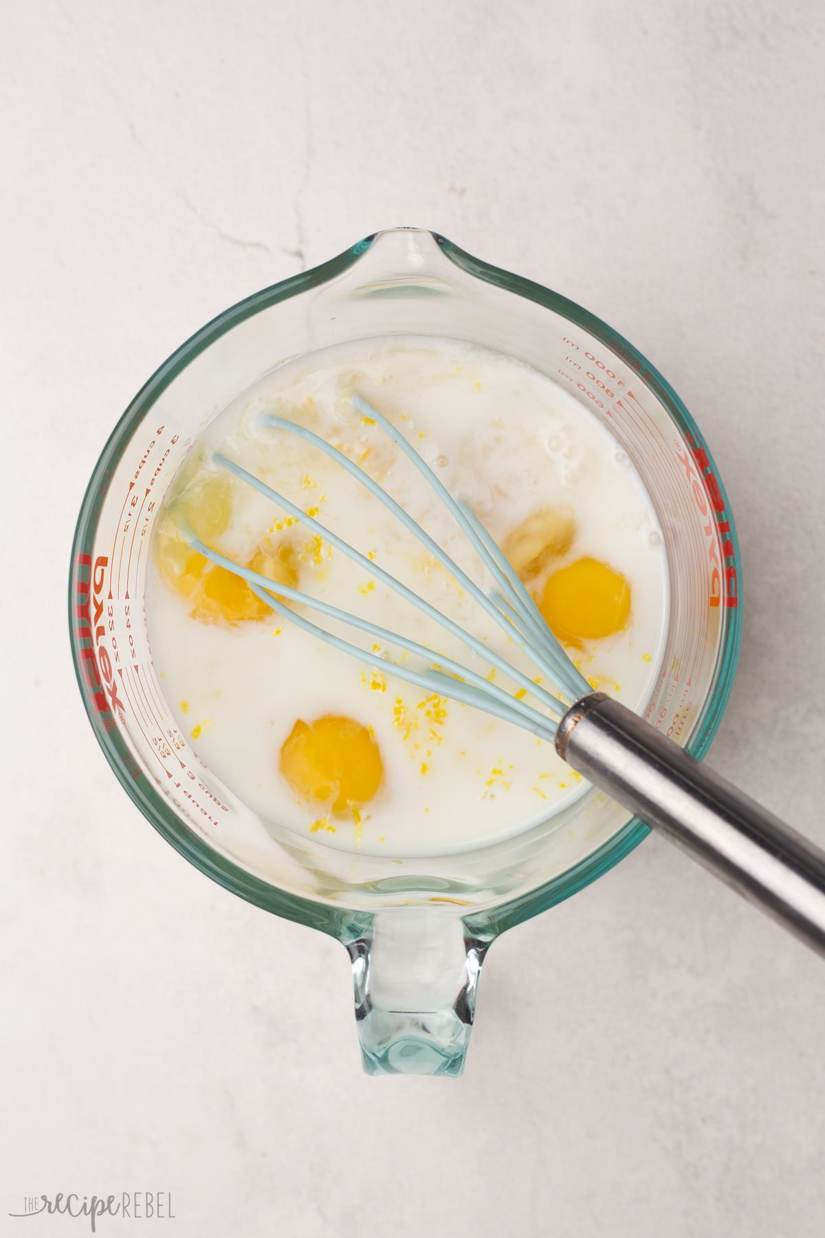 french toast egg mixture with a whisk in a glass measuring cup.