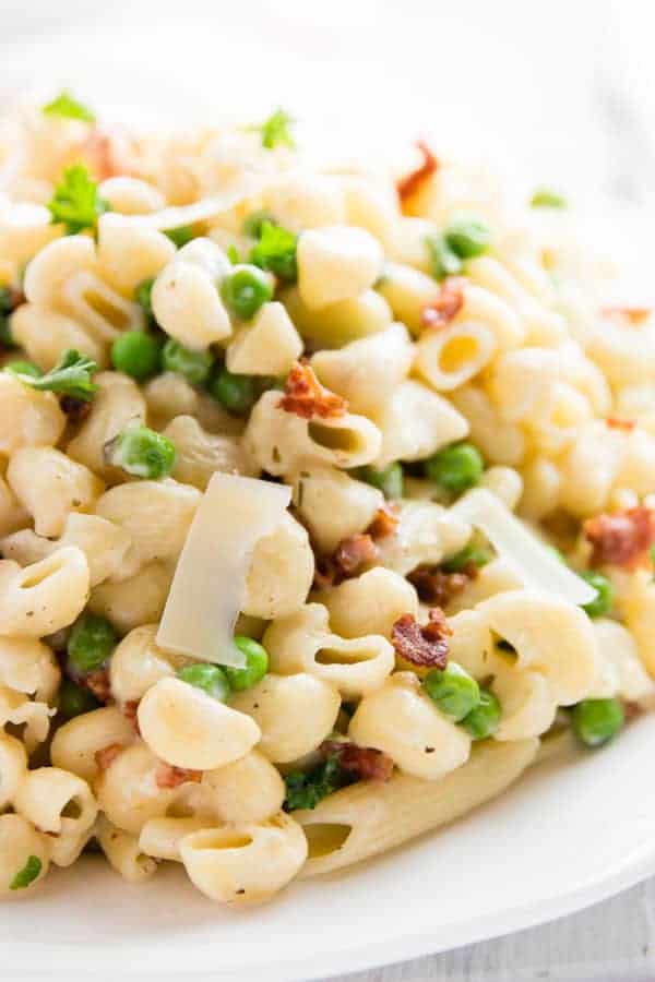 one pot pea and bacon pasta close up with shreds of fresh parmesan