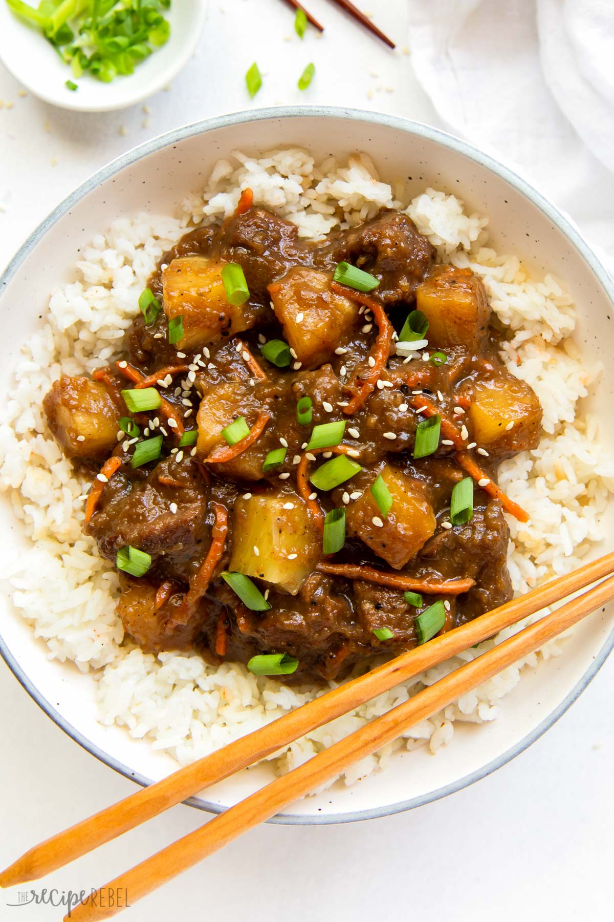 This Slow Cooker Mongolian Beef with Pineapple is made up of tender strips of steak cooked low and slow in a rich, sweet, sticky, and slightly spicy sauce. It’s a classic Asian takeout dish you can easily make right at home! #slowcooker #recipes #dinner | crockpot meals | slow cooker recipes | easy dinner ideas | asian food | steak | beef recipes overhead image of slow cooker mongolian beef with pineapple on plate