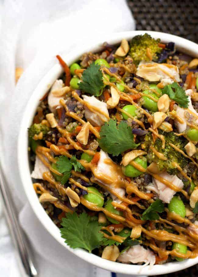 one pot thai quinoa bowls in white bowl with cilantro and drizzle of peanut sauce