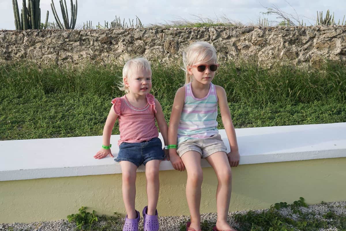 two girls sitting on ledge in aruba