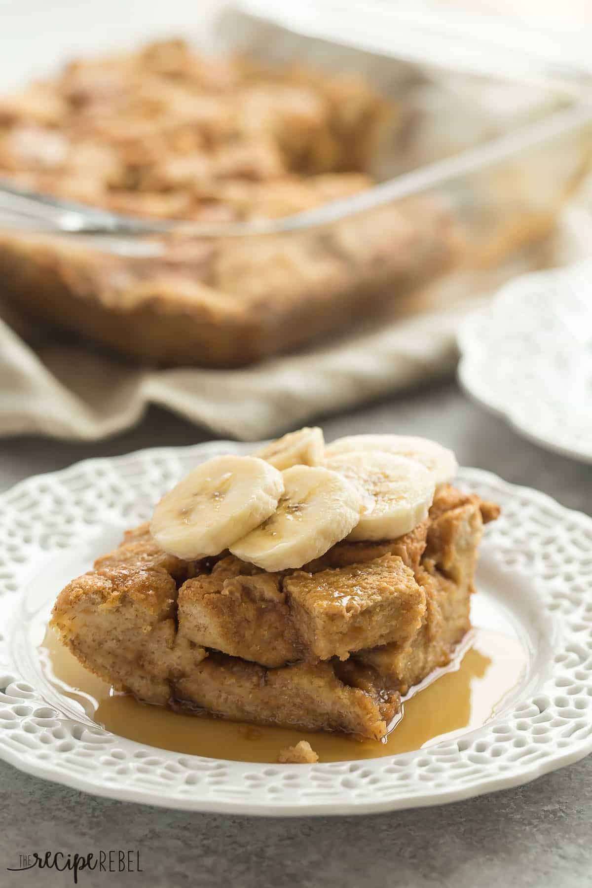 piece of peanut butter french toast on white plate with sliced bananas and syrup with pan in background