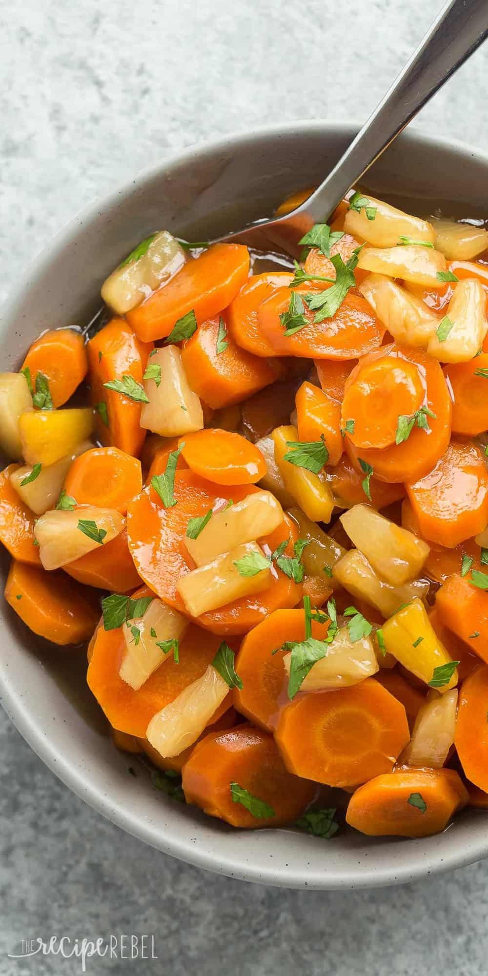 overhead close up image of carrots and pineapple in grey bowl