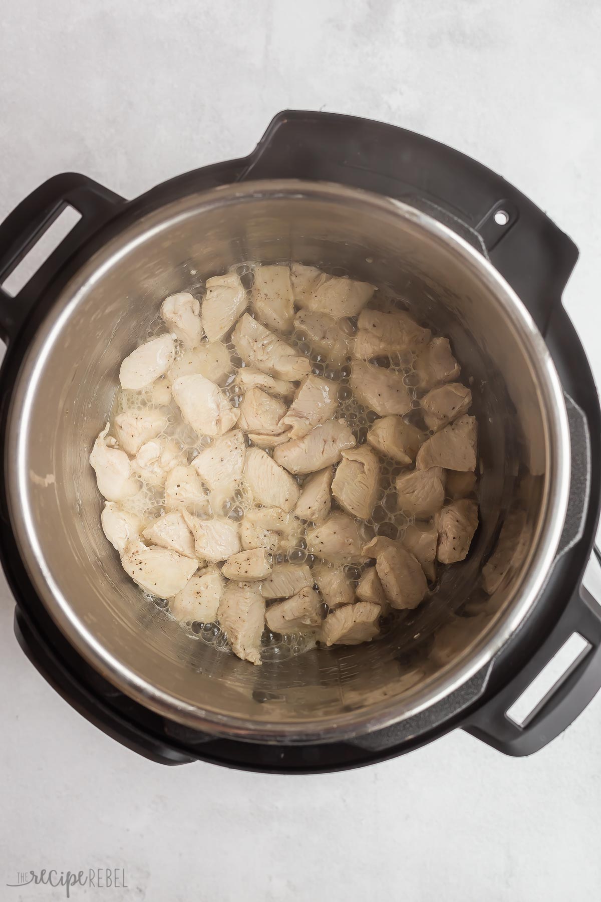 chicken pieces cooking in pressure cooker.