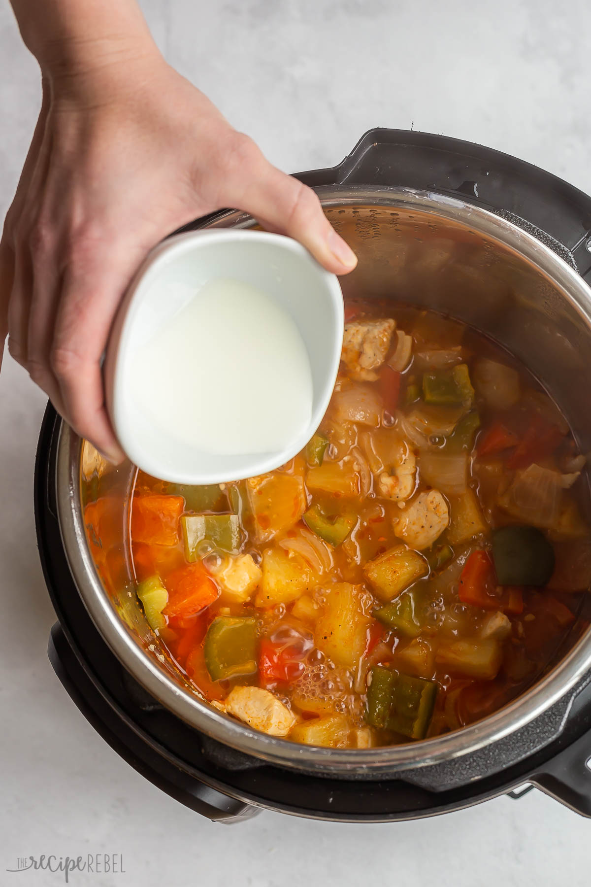 corn starch slurry being added to instant pot sweet and sour chicken.