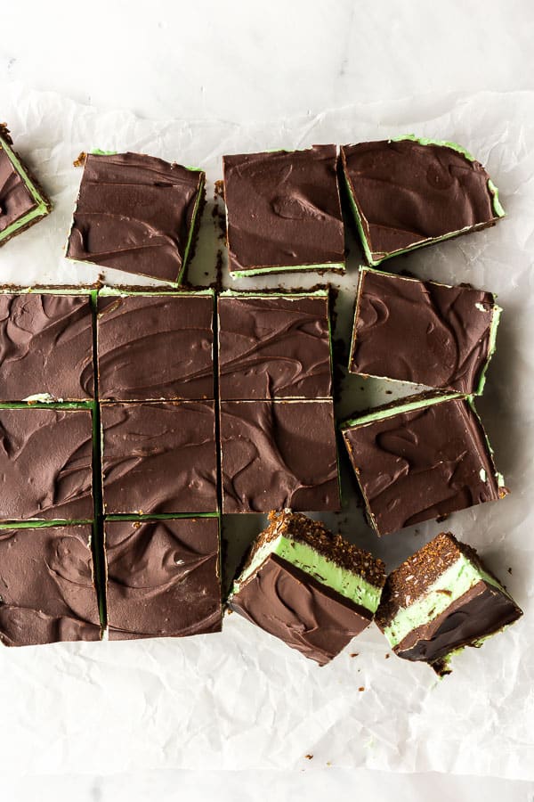 These No Bake Mint Chocolate Bars are made with a no bake graham cracker crust and topped with a creamy mint filling and chocolate ganache! #mint #chocolate #bars #christmas #baking overhead image of mint chocolate bars cut into squares