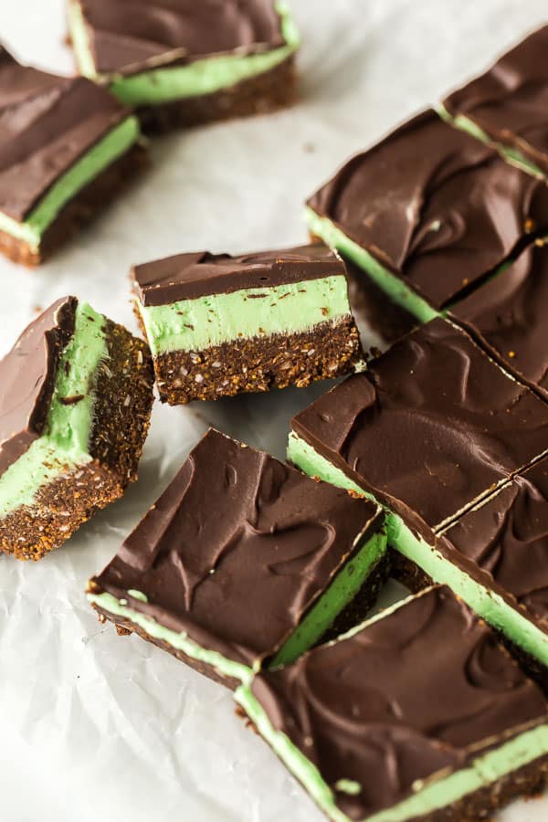 These No Bake Mint Chocolate Bars are made with a no bake graham cracker crust and topped with a creamy mint filling and chocolate ganache! #mint #chocolate #bars #christmas #baking close up of mint chocolate bars on wax paper