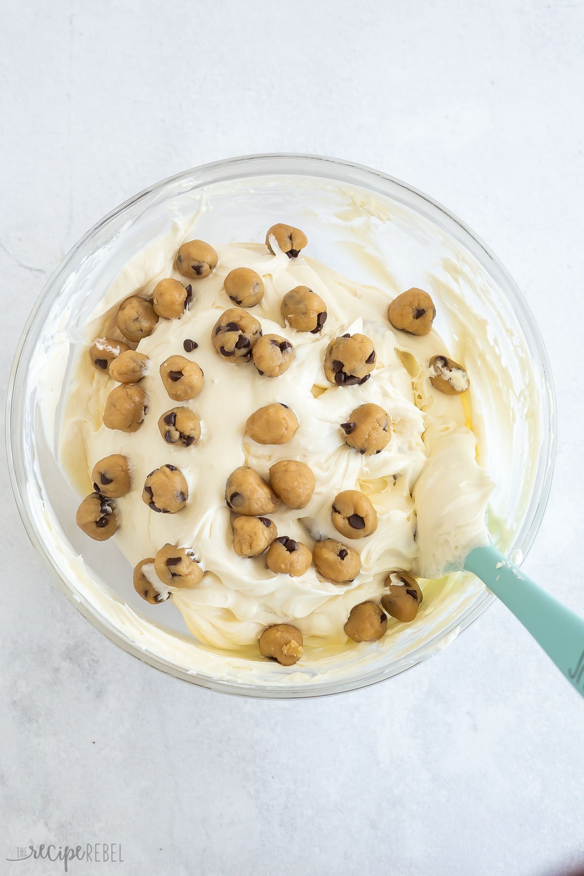 cookie dough balls being folded into cheesecake filling.