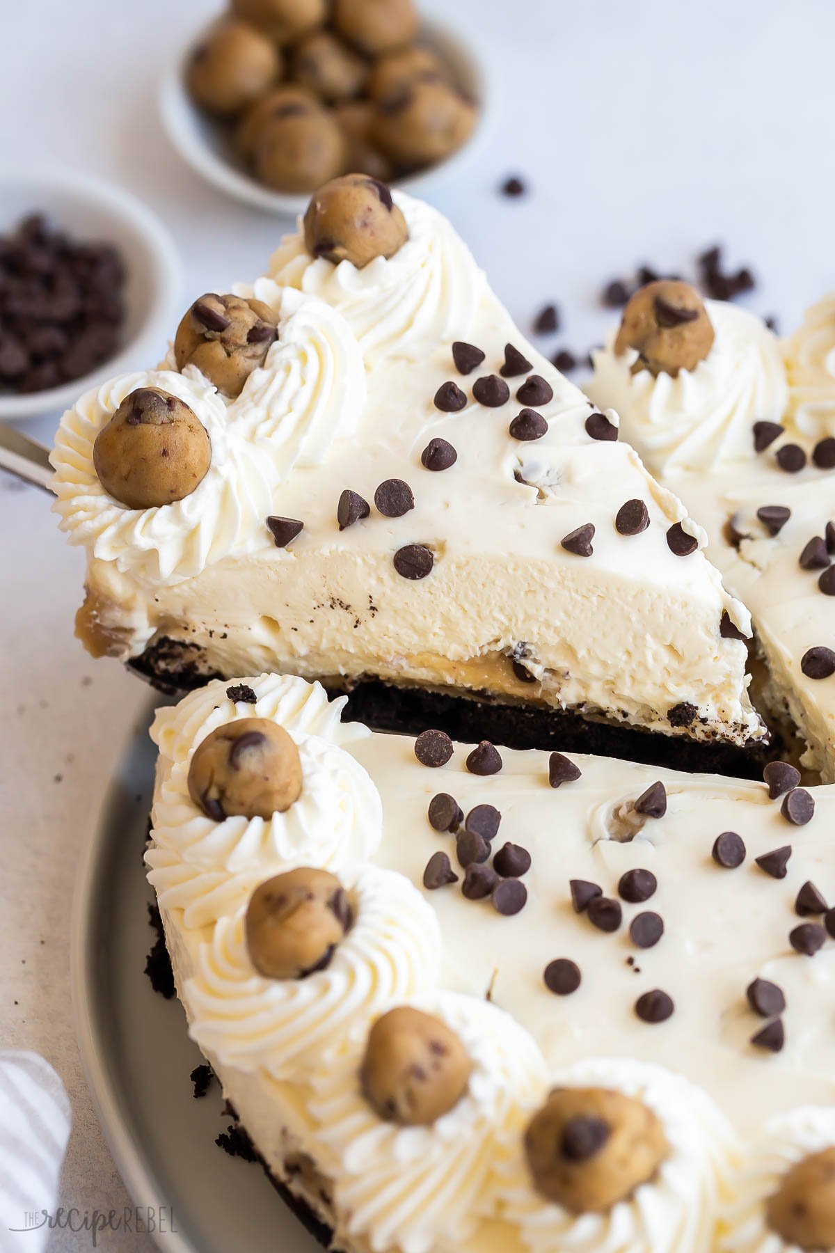 close up image of piece of cookie dough cheesecake being lifted out of whole.