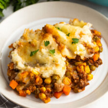 shepherds pie on a plate with a sprinkle of parsley.