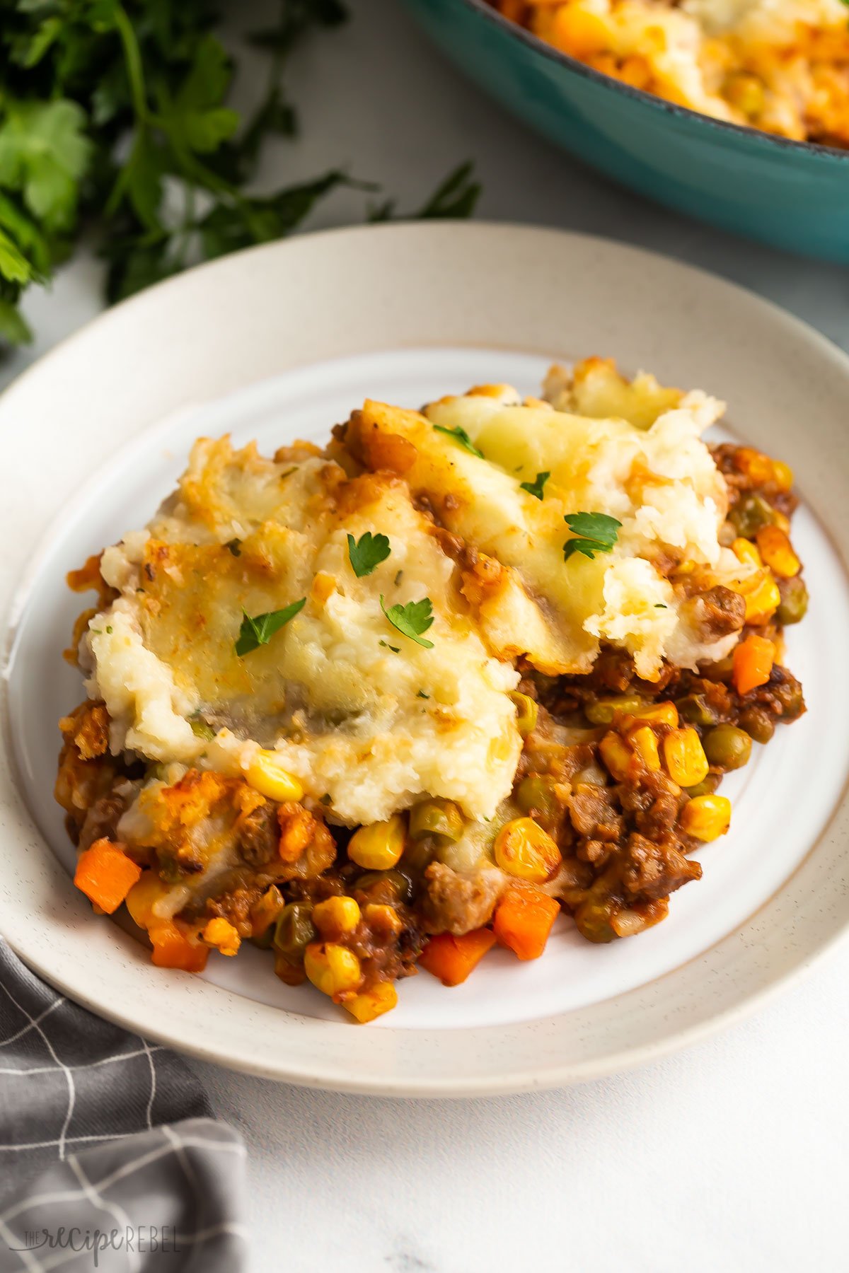 shepherds pie on a plate with a sprinkle of parsley.