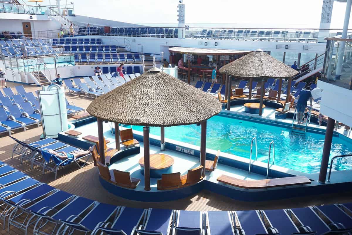 one of the pools on carnival sunshine with blue lounge chairs