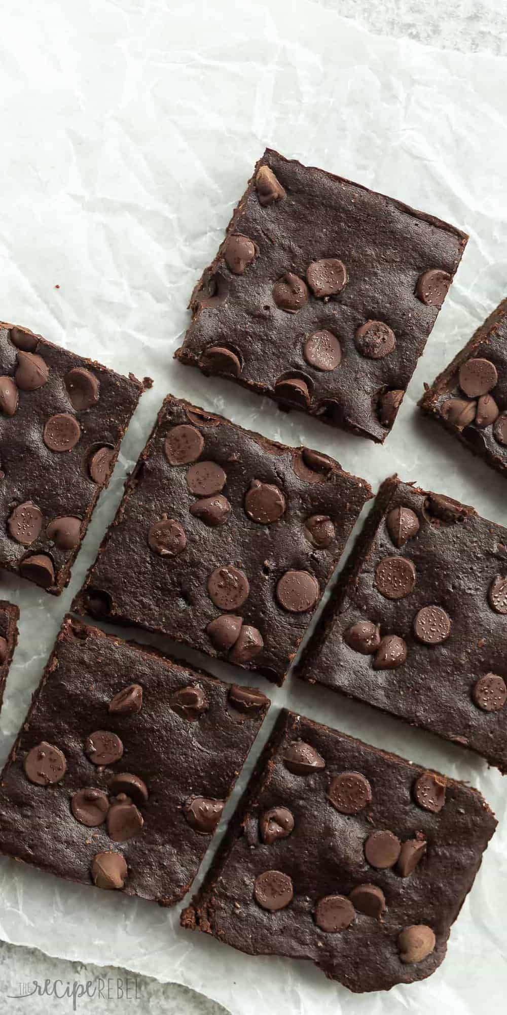 These are the BEST healthy brownies! They are SO fudgy and made with whole wheat flour, coconut oil, applesauce and have reduced sugar. overhead image of healthy brownies cut in squares with chocolate chips on top