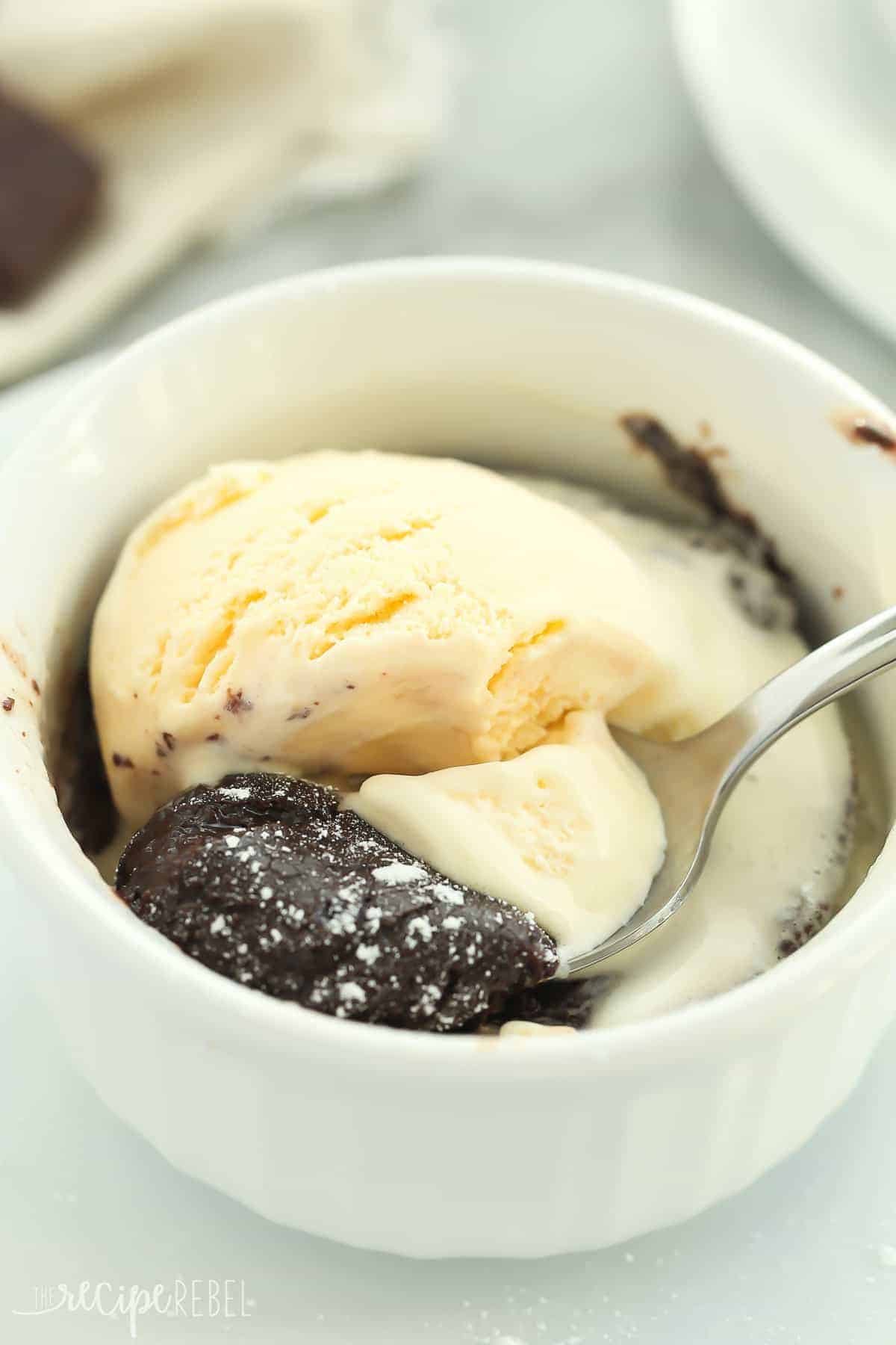 close up of melting chocolate cake with ice cream and spoon scooping a bite