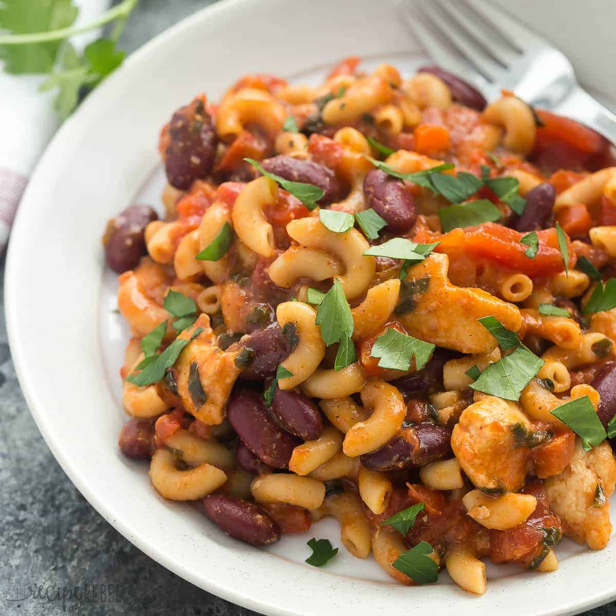 square image of plate of bbq chicken chili mac with fresh parsley