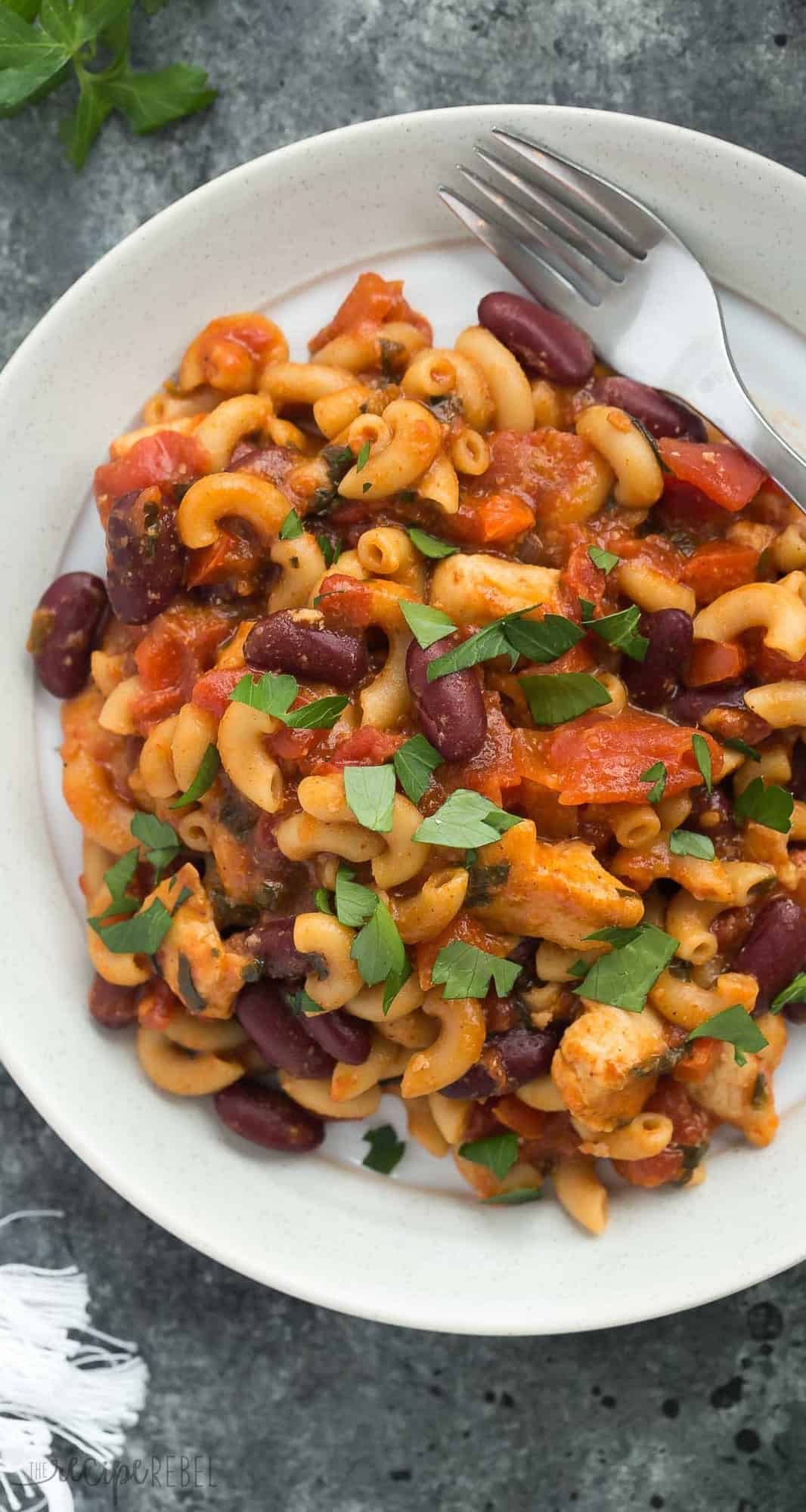 overhead close up image of plate of bbq chicken chili mac with fresh parsley