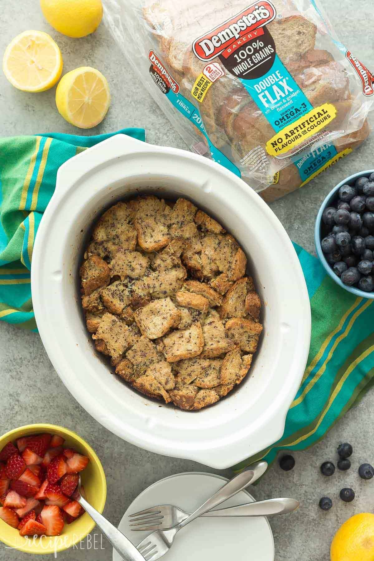 lemon french toast in slow cooker overhead with fresh lemons blueberries and Dempsters bread