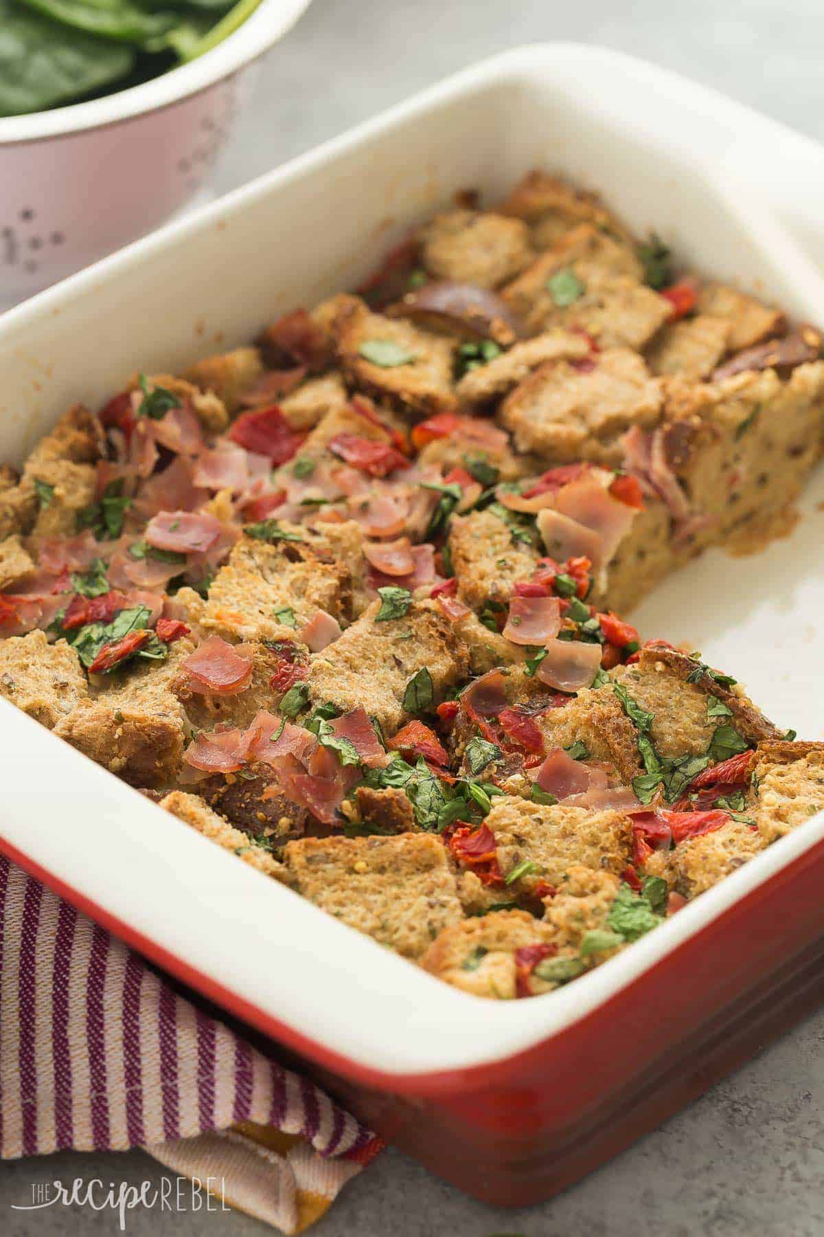 spinach and ham breakfast casserole in red and white baking dish with one piece cut out