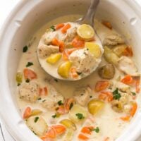 slow cooker with garlic parmesan chicken stew in it and a metal ladle