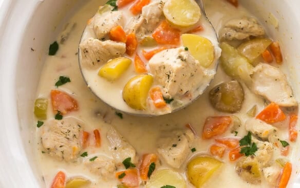 slow cooker with garlic parmesan chicken stew in it and a metal ladle