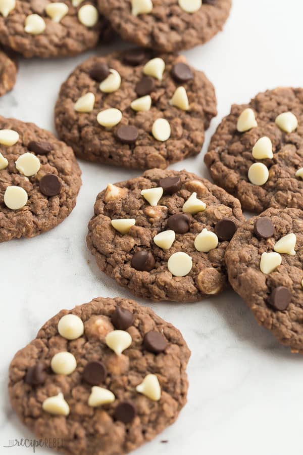 chocolate oatmeal cookies on white marble background with white and dark chocolate chips