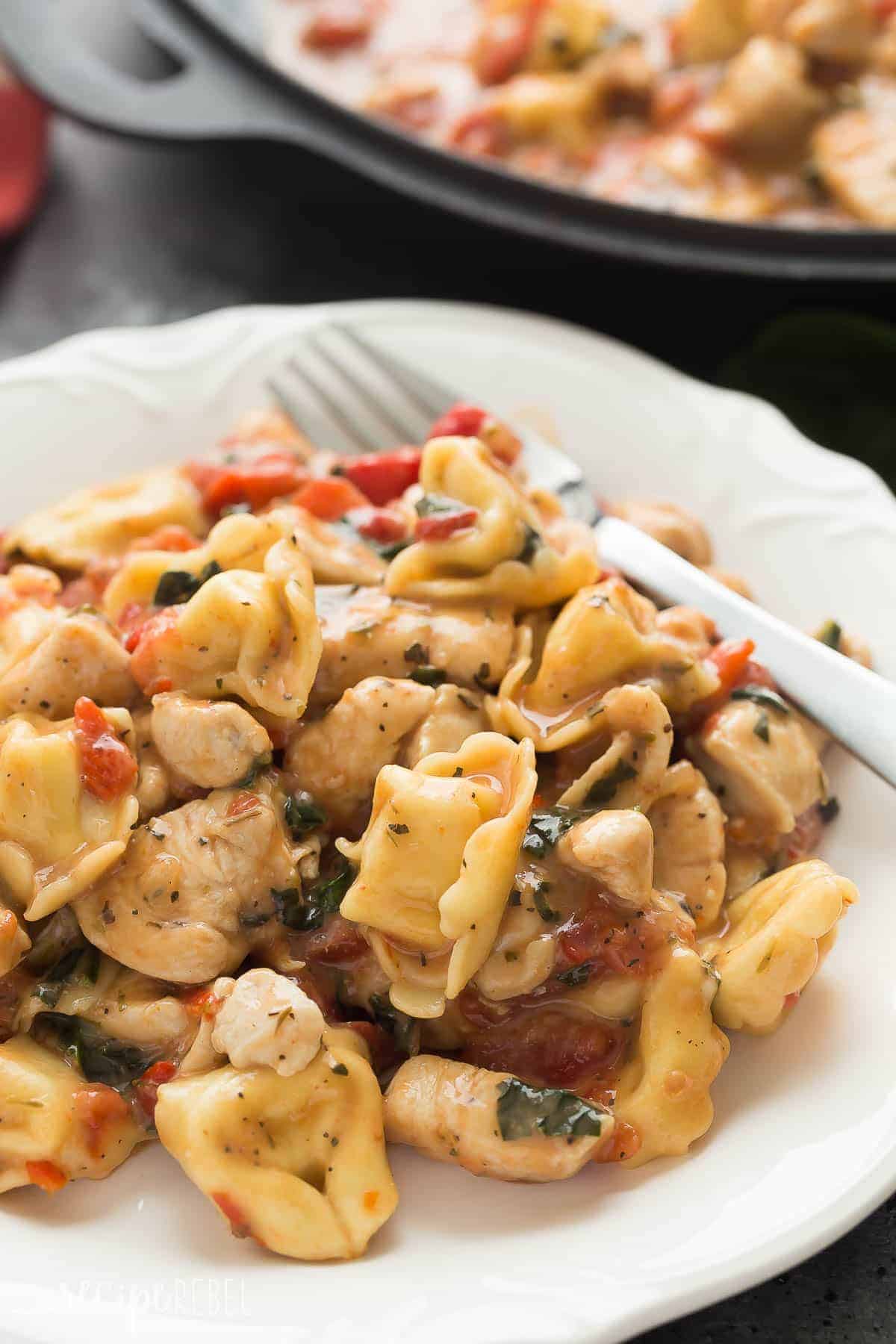 italian chicken tortellini skillet on white plate with fork on the side