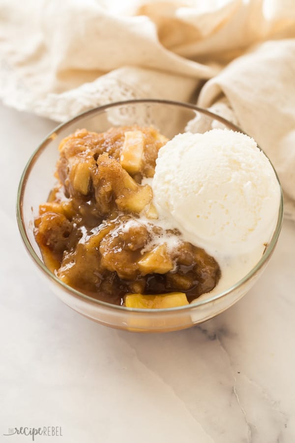 caramel apple pudding cake in bowl with vanilla ice cream