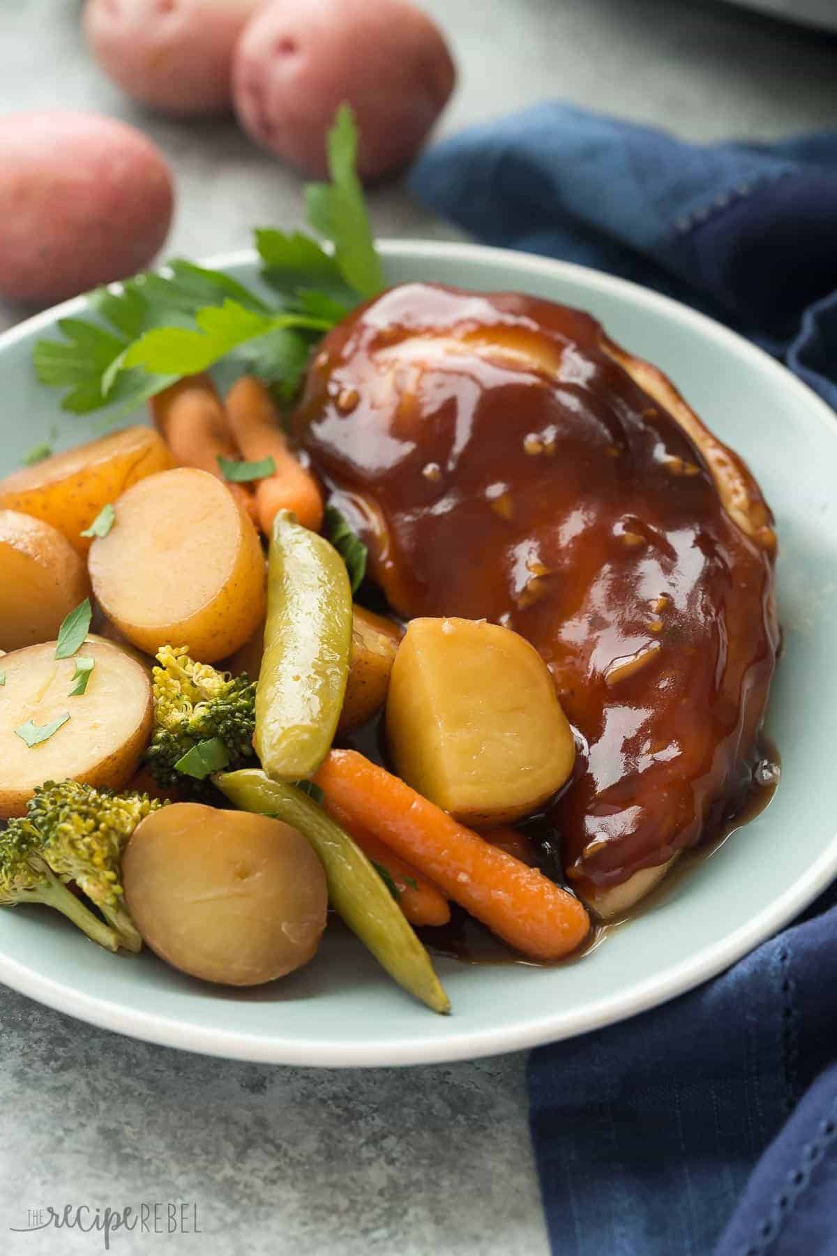 close up image of honey garlic chicken breast and vegetables on blue plate