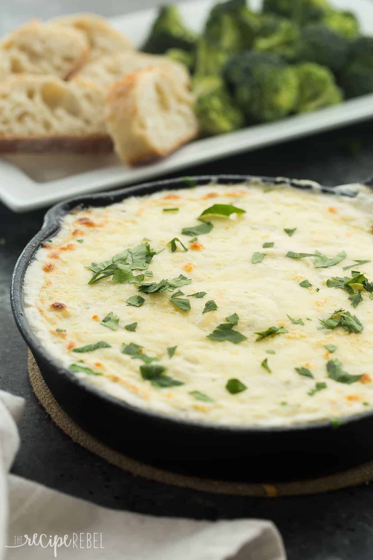 cheesy chicken alfredo dip in small cast iron skillet topped with fresh parsley