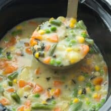 slow cooker creamy vegetable soup being pulled out of crockpot in metal ladle