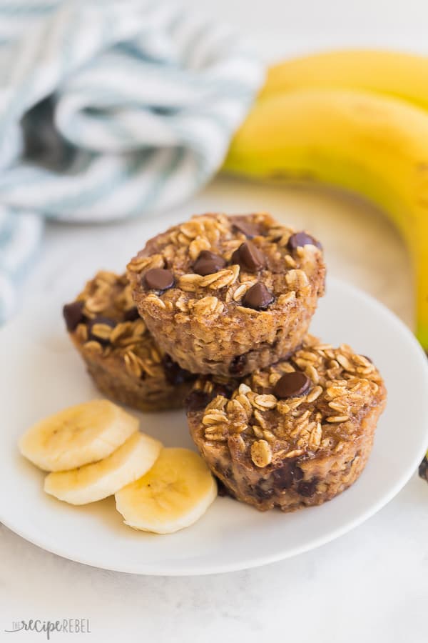 oatmeal cups stacked on white plate with blue towel and bananas in the background