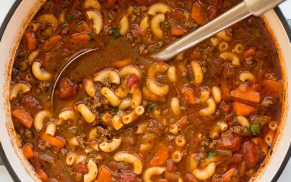 overhead image of macaroni soup with ladle stuck in