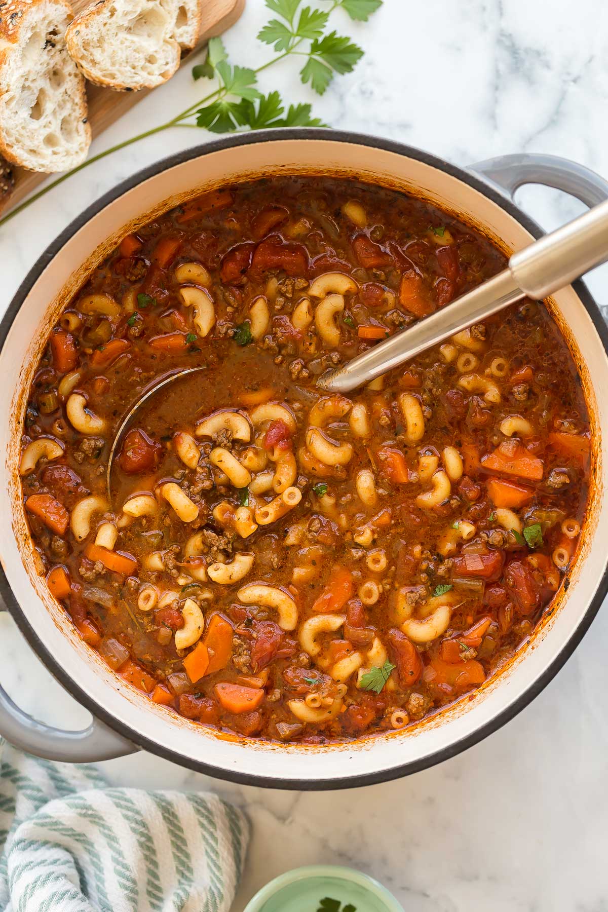 overhead image of macaroni soup with ladle stuck in