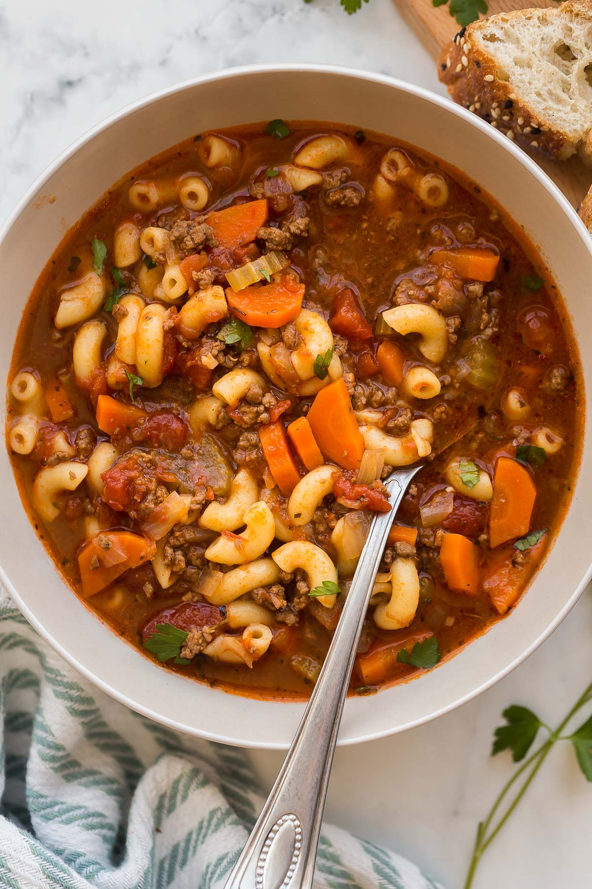 overhead image of beef tomato macaroni soup with spoon stuck in