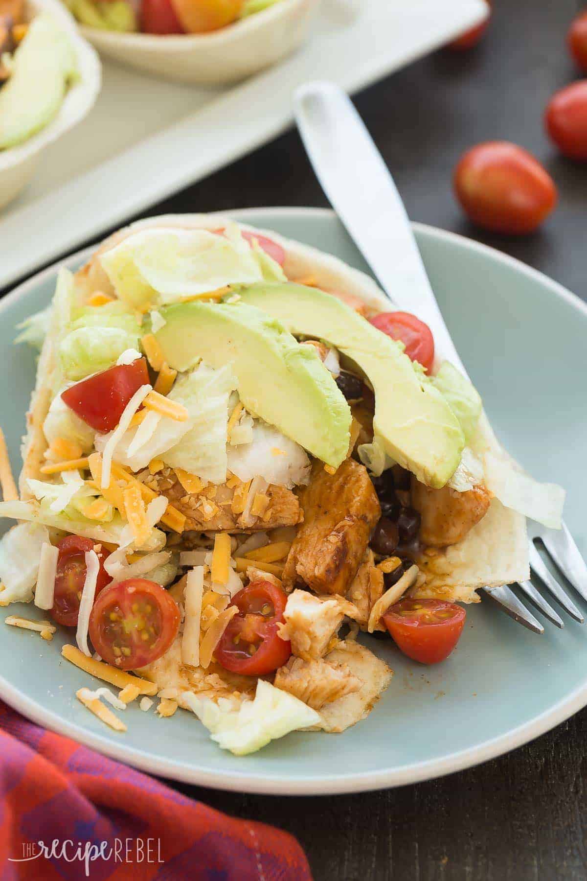 bbq chicken taco bowls on blue plate with fork cut open