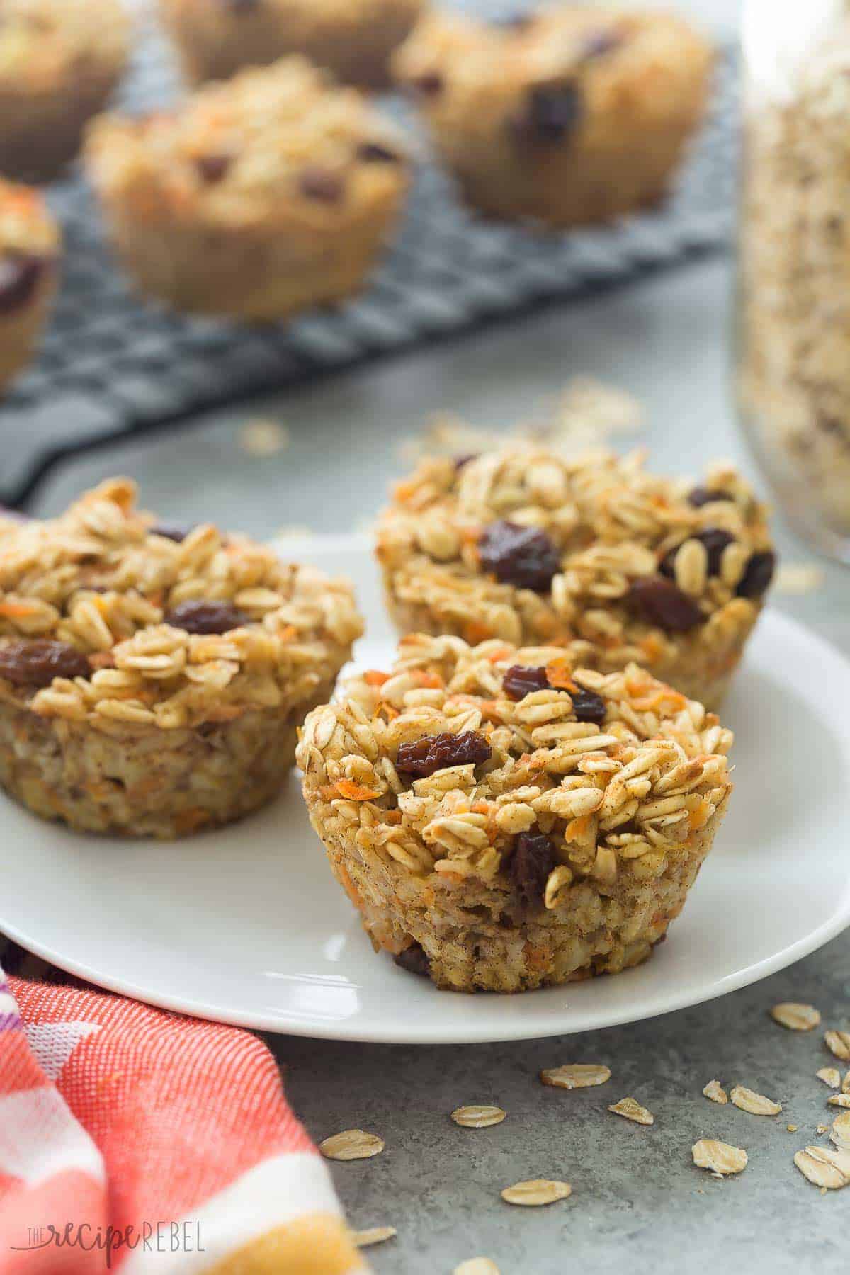 carrot cake baked oatmeal cups three on a white plate with cooling rack in the background