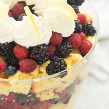 This Lemon Berry Trifle is made up of a homemade Greek Yogurt Lemon Cake, vanilla pudding, whipped cream and piles of fresh berries! It is the perfect summer dessert! Includes step by step recipe video | lemon dessert | spring dessert | easy recipe | Easter | Christmas dessert | baking